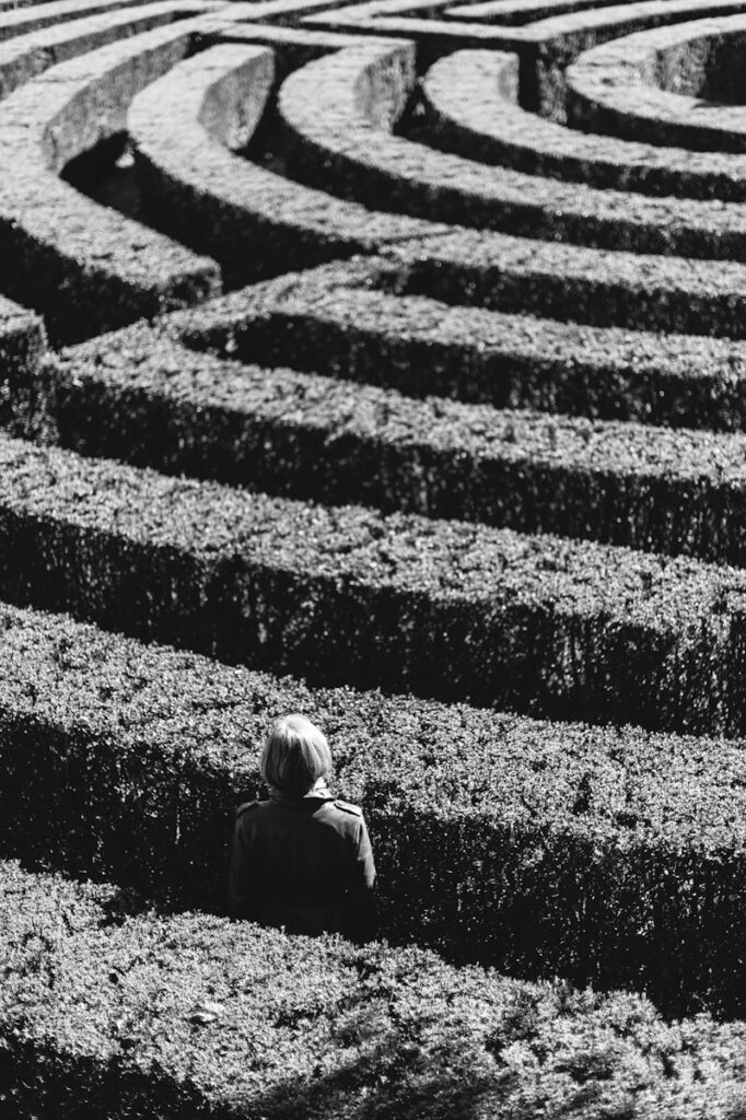 Person standing in the middle of a maze, symbolizing feeling stuck or overwhelmed by perfectionism.