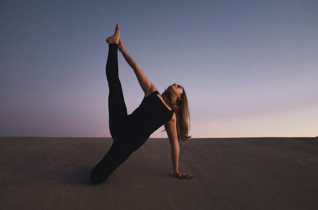 Woman practicing calming yoga outdoors, representing mindfulness and self-care in therapy for BFRBs like trichotillomania and skin picking