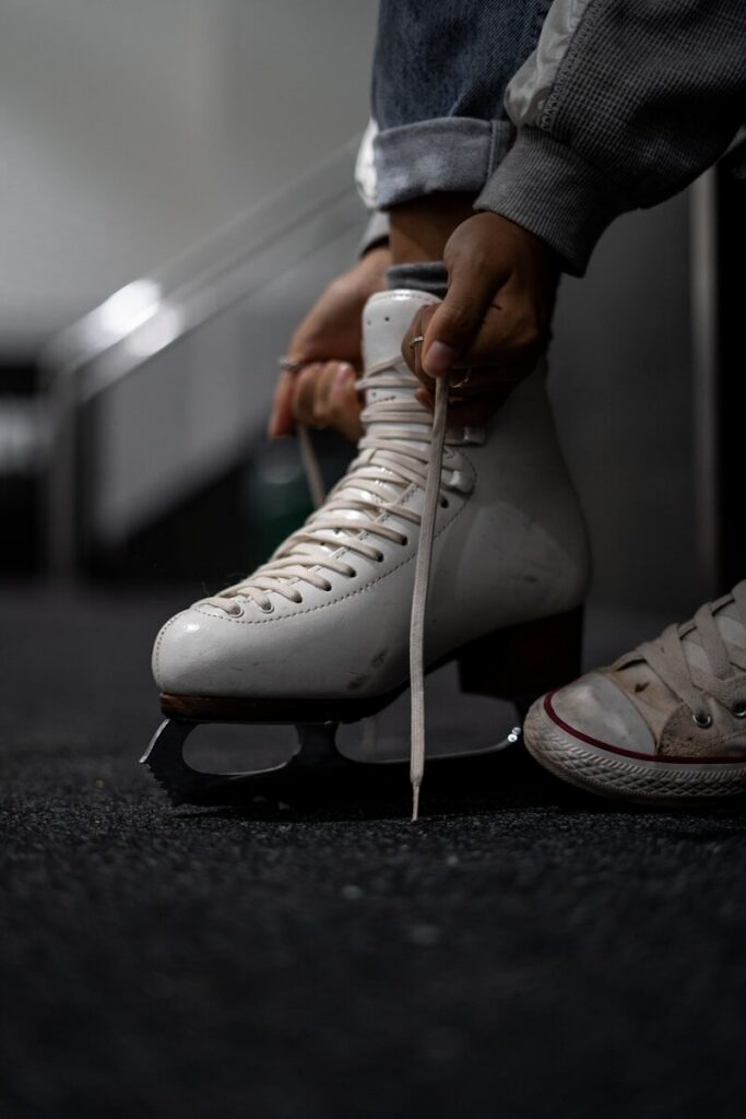 Young figure skater tying skate laces, symbolizing anxiety in kids and the pressure of performance