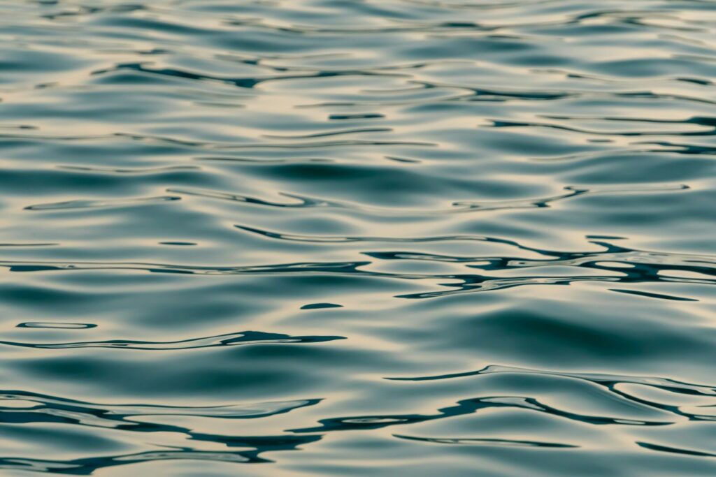 Calm water with gentle ripples, reflecting the sky, symbolizing mental clarity and stillness.
